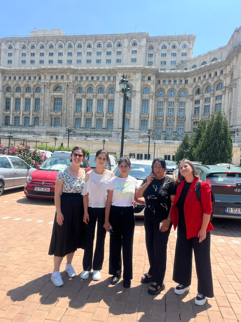 Reprezentante ale grupului fotografiate în fața Parlamentului